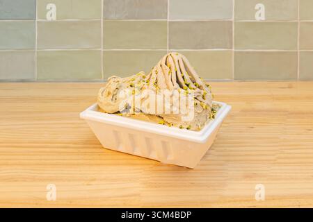 Schokoladen-Chip-Cookie-Eisbecher, vollgepackt mit Schokoladen-Chips und rohen Keks-Teigstücken Stockfoto