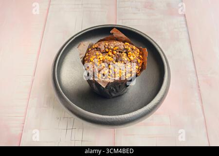 Karotten- und Walnussmuffins mit cremigem Käsefrosting, angeordnet auf einer porzellanplatte mit Blattgold zum Sammeln Stockfoto