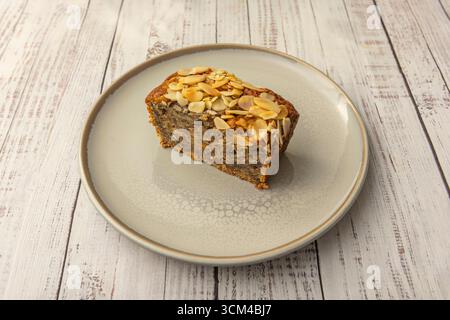 Karotten-Biskuitkuchen mit Walnussteilen und Rosinen, bestreut mit Zimt und garniert mit einem glatten Frischkäse-Frosting und rustikaler Dekoration Stockfoto