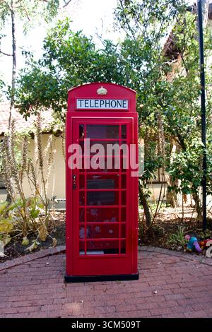 Rote britische Telefonzelle im Garten Stockfoto