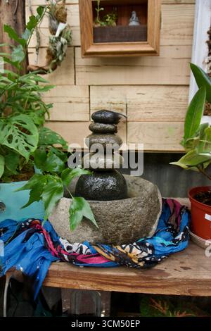 Zen-Steinbrunnen mit gestapelten Felsen und Pflanzen Stockfoto