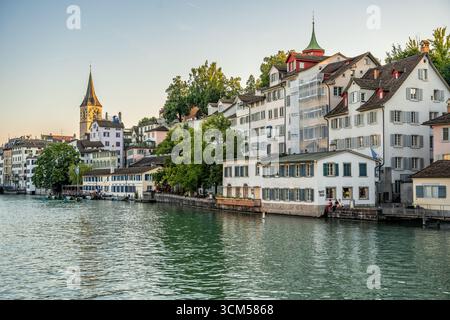 Malerischer und ruhiger Blick auf Zürich und die Limmat bei Sonnenuntergang vom Limmatquai in Zürich, Schweiz. Stockfoto