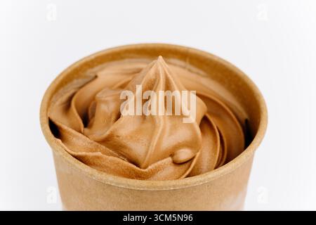Schokoladeneis in Öko-Pappbecher auf weißem Hintergrund, minimales Design Stockfoto