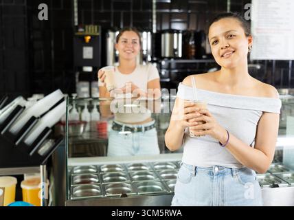Junge Frau trinkt im Café Sprudeltee Stockfoto