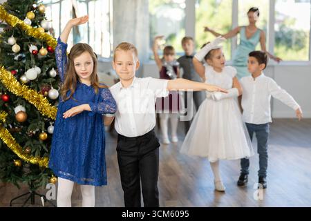 Tween Junge und Mädchen spielen Walzer während der Weihnachtsfeier in der Schule Stockfoto