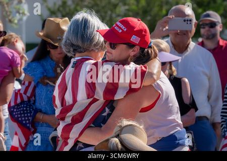 Key West, Usa. September 2025. Zwei Frauen umarmen sich bei einer Veranstaltung, um Charlie Kirk in Key West zu gedenken. Kirk, Mitbegründer von Turning Point USA, wurde am 10. September 2025 bei einer Veranstaltung an der Utah Valley University erschossen. (Foto: Jen Golbeck/SOPA Images/SIPA USA) Credit: SIPA USA/Alamy Live News Stockfoto