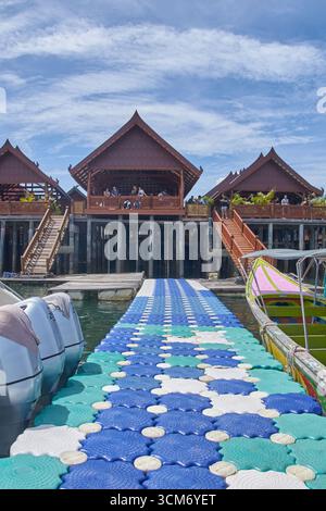PHUKET, THAILAND - 12. NOVEMBER 2017: Schwimmender Fußweg zum Restaurant am Ufer mit traditioneller Architektur an sonnigen Tagen. Stockfoto