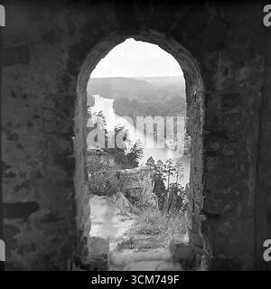 Ein majestätischer Blick auf das Tal des Sewerski Donets in Sviatohirsk, ukrainische SSR, die Mitte der 1960er Jahre erfasst wurde Die atemberaubende Landschaft, eingerahmt von einem alten Steinbogen, offenbart den gewundenen Fluss und die waldbedeckten Hügel, die die reiche Geschichte und die tiefgreifende natürliche Schönheit der Donbass-Region symbolisieren. Dieses Foto ist ein Paradebeispiel der sowjetischen Landschaftsfotografie aus der Chruschtschow-Tauzeit, die die friedliche, kontemplative Atmosphäre des wichtigsten Touristenziels der Region widerspiegelt, eine Welt fern von zukünftigen Konflikten Stockfoto