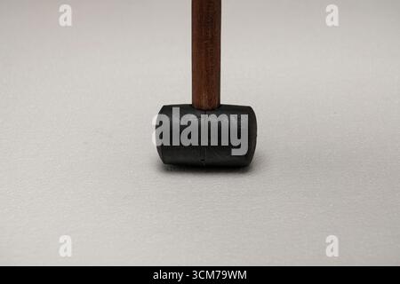 Nahaufnahme eines Gummihammers mit Holzgriff auf einer hellen Oberfläche Stockfoto