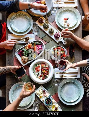 Ein abwechslungsreiches kulinarisches Erlebnis mit Freunden, die gemeinsam genießen und besondere Momente feiern Stockfoto