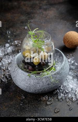 Eine elegante und atemberaubende Präsentation von Oliven und frischen Kräutern, kunstvoll auf Eis angeordnet Stockfoto