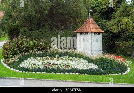 Spiez, Schweiz - 11. September 2025: Ein wunderschön angelegter Garten in Spiez mit bunten Blumen und einem kleinen Turm. Stockfoto