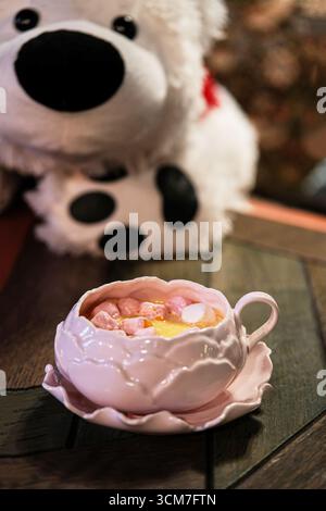 Gemütliche und warme heiße Schokolade mit köstlichen Marshmallows und einem Plüschbären-Begleiter Stockfoto