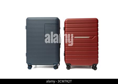 Blaue und rote Hartschalenkoffer nebeneinander. Modernes Reisedesign mit Strapazierfähigkeit und Style. Reisekoffer isoliert auf weißem Hintergrund. Stockfoto