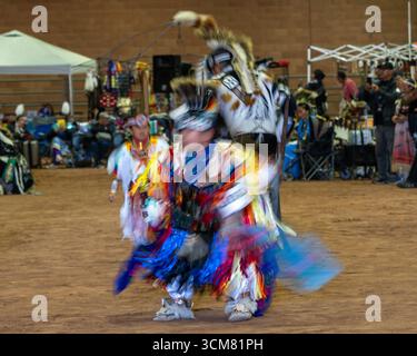 Ein abstraktes Foto der Tänzerinnen im Powwow der Ureinwohner in Moab, Utah. Eine langsame Verschlusszeit erzeugt Bewegungsunschärfe, die ein Gefühl für die Bewegung vermittelt Stockfoto