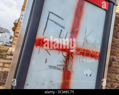 Paignton, Großbritannien. September 2025. Traditionelle rote Telefonbox mit Fenstern, die mit Graffiti der rot-weißen Flagge von St. George, der Nationalflagge Englands, bedeckt sind. Autor: Thomas Faull/Alamy Live News Stockfoto