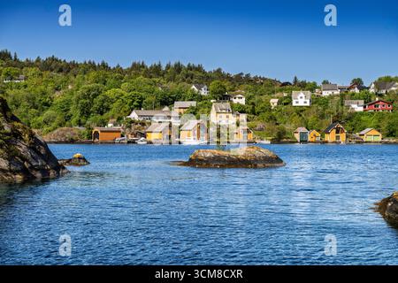 Ruhige Landschaft mit einem ruhigen See umgeben von Bäumen, einer kleinen Insel, lebendigem Grün und einem klaren blauen Himmel, der von Wolken hervorgehoben wird. Ein Perfec Stockfoto