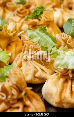 Goldene gebratene Knödel in Beutelform mit frischem Salat - appetitlicher warmer Snack Stockfoto