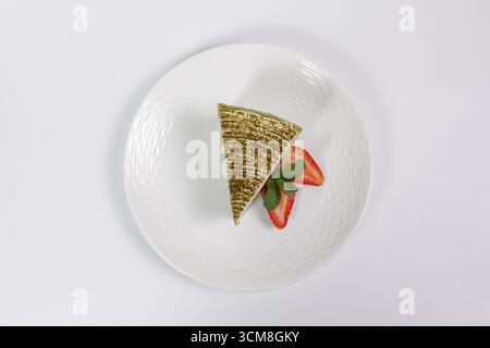 Spinat-Käsekuchen-Scheibe mit Erdbeeren und Minze von oben auf weißem Hintergrund Stockfoto