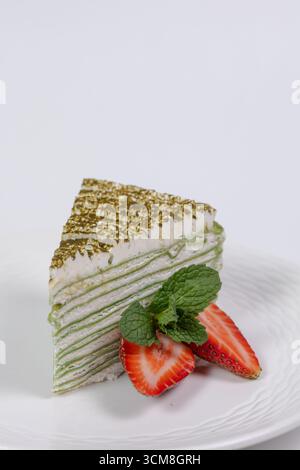 Spinat-Käsekuchenscheibe mit Erdbeeren und Minze auf weißem Hintergrund Stockfoto