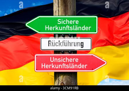Schilder mit Rückführung, sicheren Herkunftsländern und unsicheren Herkunftsländern vor der deutschen Flagge, Fotomontage Stockfoto