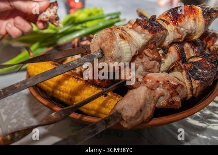 Gegrillte Fleischspieße mit geröstetem Mais in Nahaufnahme Stockfoto