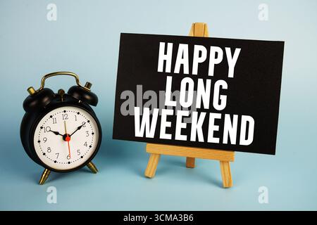 Happy Long Weekend Text mit Staffelei und Wecker auf blauem Hintergrund Stockfoto