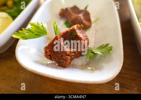 CIG Kofte (roher Fleischbällchen auf Türkisch) mit Salat, traditionelle türkische Küche, beliebt in der Türkei Stockfoto
