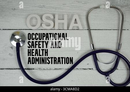 OSHA Occupational Safety and Health Administration Text mit Stethoskop auf hölzernem Hintergrund Stockfoto
