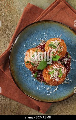 Knusprige Arancini-Vorspeise mit Parmesan und Mikrogrün, Teller, Tomatensauce, hausgemacht, keine Leute Stockfoto
