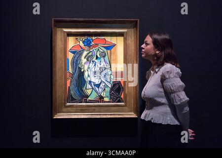 London, Großbritannien. September 2025. LONDON, VEREINIGTES KÖNIGREICH - 15. SEPTEMBER 2025: Ein Galeriemitarbeiter sieht sich „Weeping Woman“, 1937, von Pablo Picasso während eines Fotoaufrufs für die Ausstellung „Theatre Picasso“ (17. September 2025 - 12. April 2026) in der Tate Modern in London, Vereinigtes Königreich am 15. September 2025 an. Die Ausstellung zeigt einige der bekanntesten Werke Picassos aus Tates Sammlung sowie wichtige Darlehen führender Picasso-Museen in Frankreich, die in einem Theater-inspirierten Set inszeniert werden. (Foto: Wiktor Szymanowicz/NurPhoto) Credit: NurPhoto SRL/Alamy Live News Stockfoto
