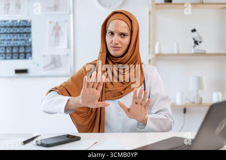 Muslimische Ärztin sagt Danke aber nein und macht Stop Geste mit ihren Händen arbeiten im Krankenhausbüro. Kopierbereich Stockfoto