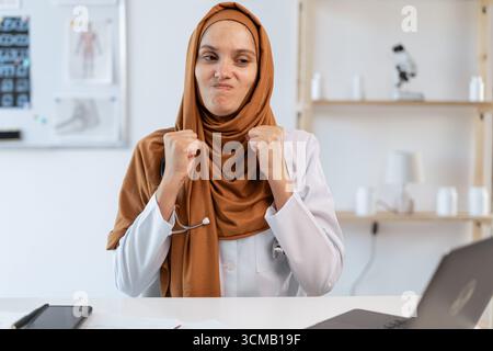 Muslimische Ärztin in Uniform mit Fäusten im Krankenhaus. Das Sprachkonzept des menschlichen Körpers Stockfoto