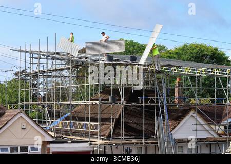 Gerüste, die eine wetterfeste Abdeckung auf einem Vorstadtbungalow vor großen Bauarbeiten errichten, Shepperton Surrey England Stockfoto