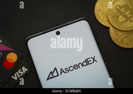 Dhaka, Bangladesch, 02. Juni 2025: Smartphone mit AscendEX-Logo, umgeben von Bitcoin-Münzen und Zahlungskarten Stockfoto