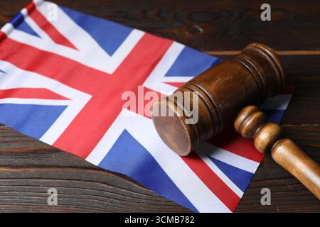 Richterlicher Hammer und Flagge von Großbritannien auf Holztisch, Nahaufnahme Stockfoto