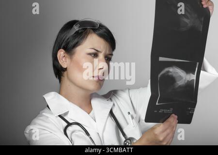 Portrait einer attraktiven jungen Frau Doktor im weißen Mantel. Lächelnd medizinische Frau Doktor. Auf weissem Hintergrund Stockfoto