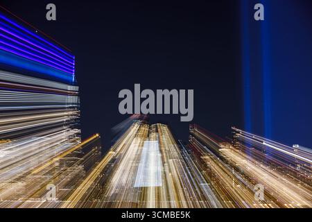 Abstrakter nächtlicher Blick auf die Skyline von New York City mit den Tribute in Light 9/11-Gedenkstrahlen, die in den Himmel leuchten. Stockfoto