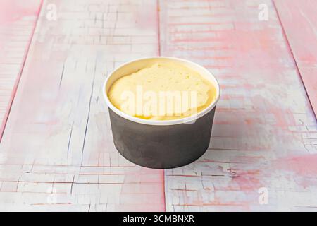 Eine Tasse Dulce de leche-Eis mit gesalzenen Karamelllocken, gehackten Walnüssen und Brownie-Stücken, exquisit ausgewogen Stockfoto