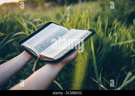 Öffnen Sie die Bibel in den Händen, Nahaufnahme, Konzept der Ruhe und der morgendlichen Einsamkeit. Stockfoto