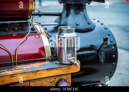 Nahaufnahme der Dampflokomotive mit Messingölkanne, roter und schwarzer Farbe und hölzernem Trittbrett bei der Parade. Stockfoto