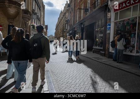 Geschäftige Straßenszene im Stadtzentrum von Cambridge, an einem sonnigen Nachmittag spazieren die Menschen vorbei an historischen Gebäuden, Geschäften und Cafés Stockfoto