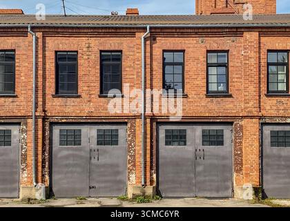 Ein alter Hangar mit Turm. Stadtfeuerwehr. Industrielle Garage, Lager, Fabrikhintergrund mit Ziegelfassade. Stockfoto