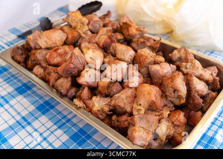 Frisch gegrillter Schaschlik auf einer blau karierten Tischdecke, Blick von oben. Appetitliche und einfache Lebensmittelfotografie. Stockfoto