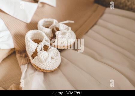 Handgemachte Babyschuhe und Kleid, Konzept der Erwartung eines Babys. Stockfoto