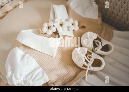 Handgemachte Babyschuhe, Stirnband und Kleid, Konzept der Erwartung eines Babys. Stockfoto