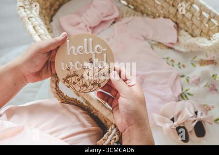 Holzbrett handgefertigt mit der Aufschrift: hallo Welt, Warten auf das Baby. Stockfoto