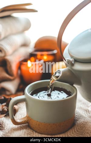 Teekanne und Tasse mit Sanddorntee, Herbststimmung. Stockfoto