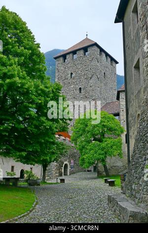 Blick auf den gepflasterten Innenhof des alten Schlosses Tirol und den Steinturm in Südtirol, Italien Stockfoto