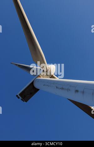 Nahaufnahme einer modernen Windturbine vor klarem blauem Himmel. Technologie für erneuerbare Energien und Konzept der nachhaltigen Stromerzeugung. Stockfoto